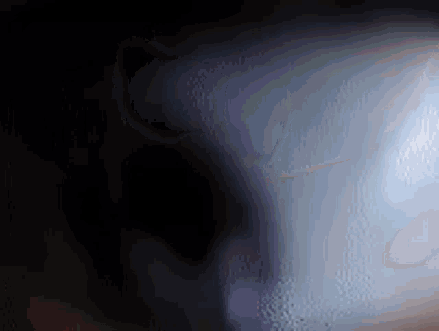 a close up of a person 's face in the dark with a blurred background .
