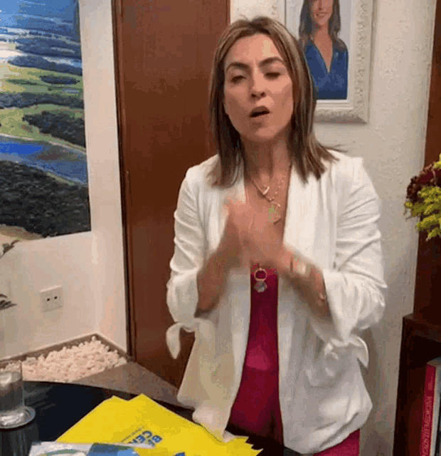 a woman in a white jacket is standing in front of a table with a yellow bag that says ' rio de janeiro '