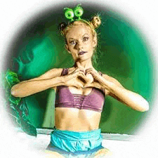 a woman in a purple bra and blue shorts is making a heart with her hands .