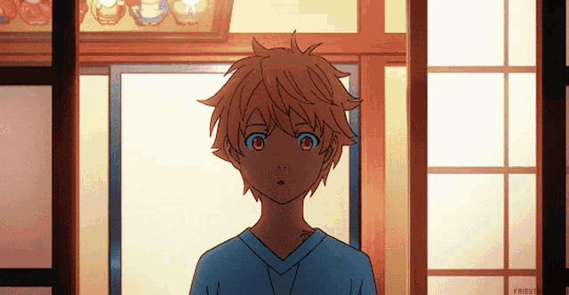 a boy in a blue shirt is standing in a room with a window