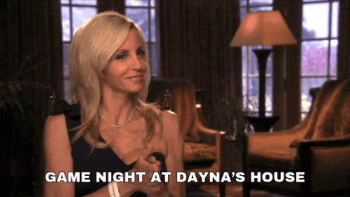 a woman sitting in a living room with the words game night at dayna 's house above her