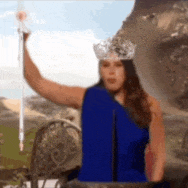 a woman in a blue dress is holding a sword