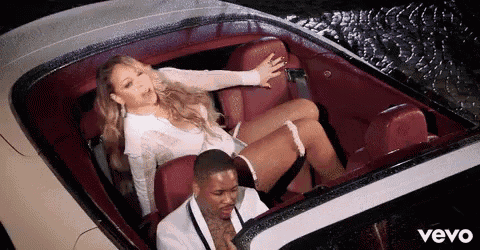 a man and a woman are sitting in a car . the woman is sitting on the man 's lap .