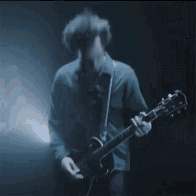 a blurry picture of a man playing a guitar