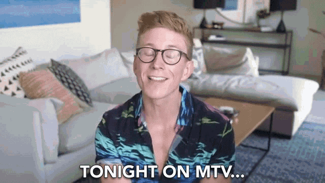 a man wearing glasses is sitting on a couch and says tonight on mtv