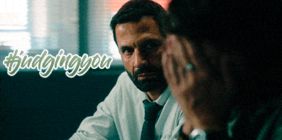 a man in a white shirt and tie is talking to another man in a dark room and the words #findingyou are above him