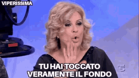 a woman blowing a kiss with the words tu hai toccato veramente il fondo