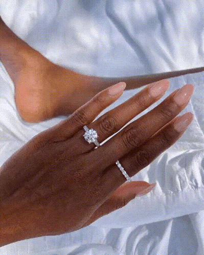 a woman 's hand with two rings on it