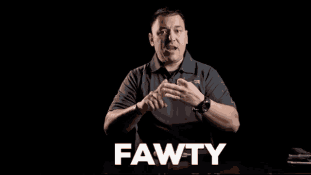 a man in a gray shirt with the word fawty in white