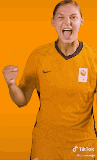 a woman wearing a yellow shirt with the word tiktok on the bottom right