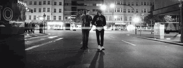 a black and white photo of two people walking down a street with a sign that says 10