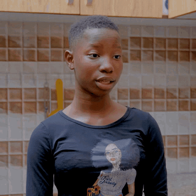 a young girl wearing a black shirt that says " true beauty " on it