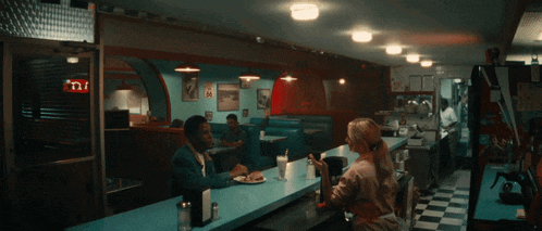 a diner with people sitting at tables and a sign that says ' n.i. ' on it