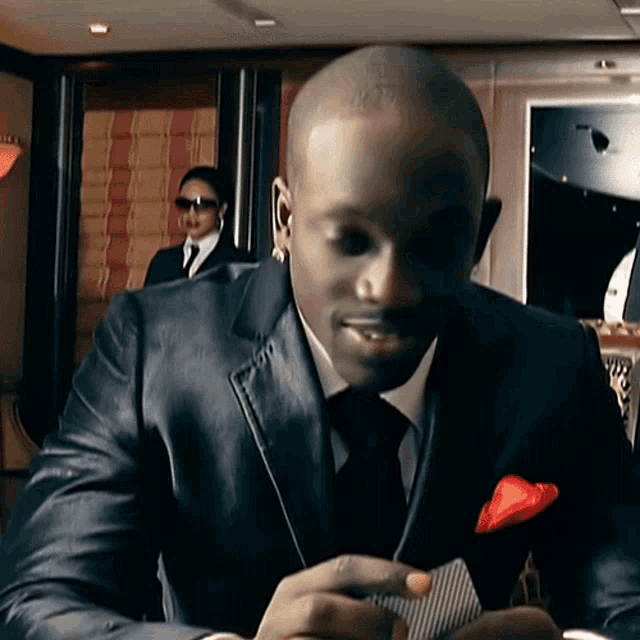 a man in a suit and tie is holding a card