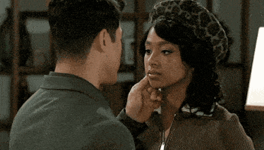 a man and a woman are kissing with the woman wearing a leopard print hat