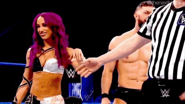 a woman with purple hair is standing next to a referee with a w on his shirt