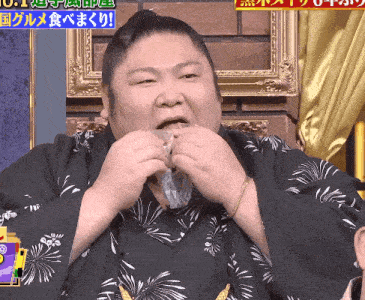 a man in a black and white kimono is eating a piece of plastic
