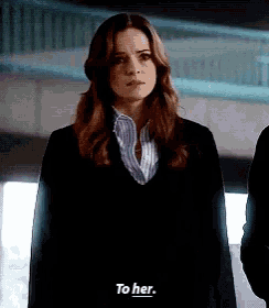 a woman in a black sweater is standing next to a man and talking to him .