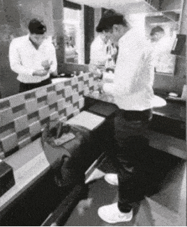 a black and white photo of a man in a bathroom