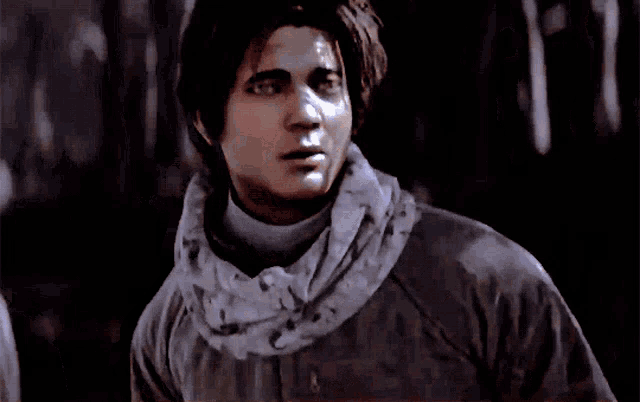 a man wearing a scarf around his neck looks at something