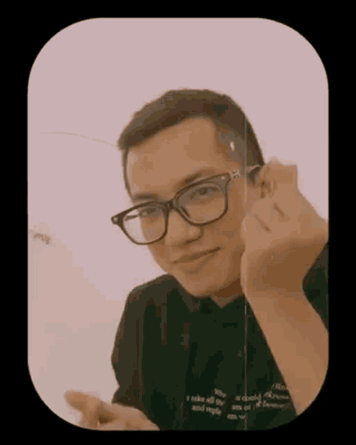 a man wearing glasses is making a funny face and giving the middle finger .