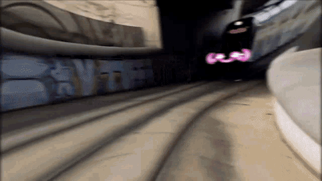 a train going through a tunnel with graffiti on the walls