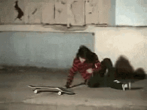 a person laying on the ground with a skateboard on the ground .