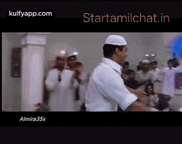 a man in a white shirt is dancing in front of a crowd of people .