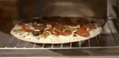 a pizza is being cooked in an oven on a rack .
