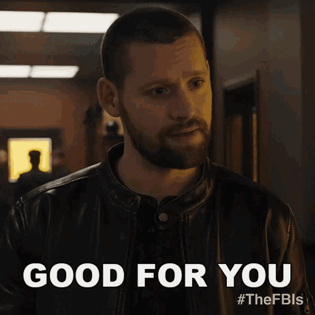 a man with a beard is wearing a black leather jacket and says good for you