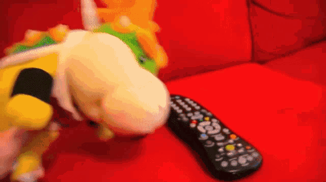 a stuffed animal is playing with a remote control that says ' nintendo ' on it