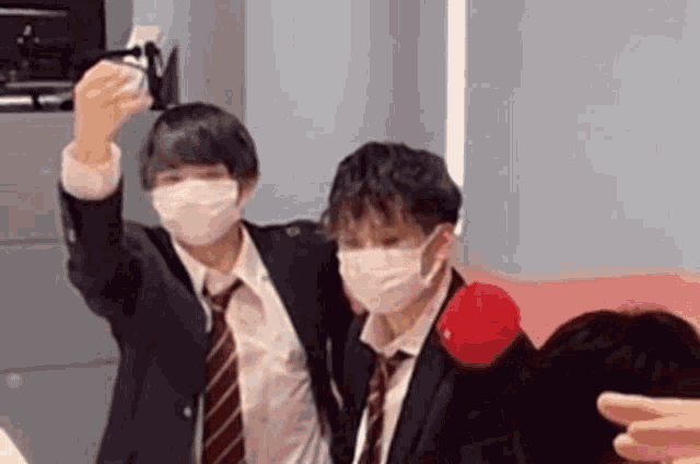 a group of young men wearing masks are standing next to each other .