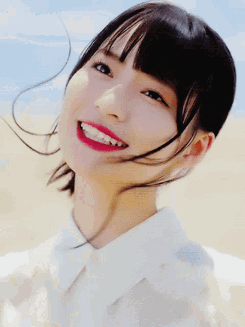 a close up of a woman 's face with a white shirt