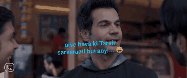 a group of men are sitting at a table with the words " aise hava ki tarah " written above them