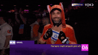 a man in a fox costume holds a flag with the word israel on the bottom right