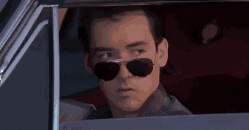a man wearing sunglasses is sitting in a car .