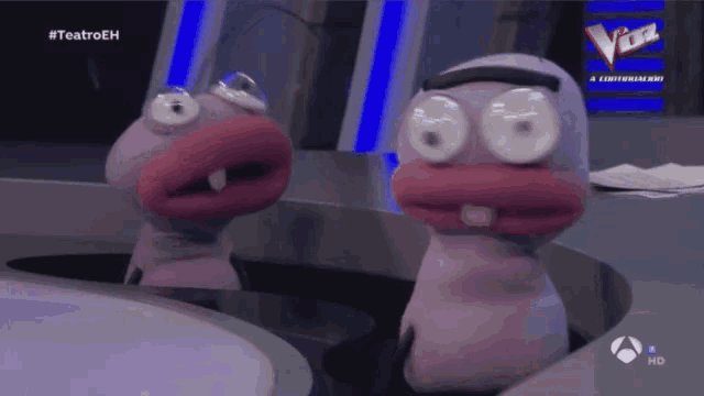 two stuffed animals are sitting in front of a sign that says teatroeh on it
