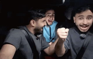 three men are sitting in the back seat of a car with their mouths open