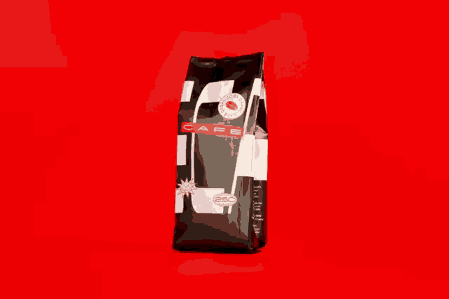 a black and white bag of coffee on a red background that says ' caffeine ' on it