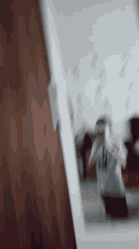 a blurred image of a person standing in front of a white board with numbers on it