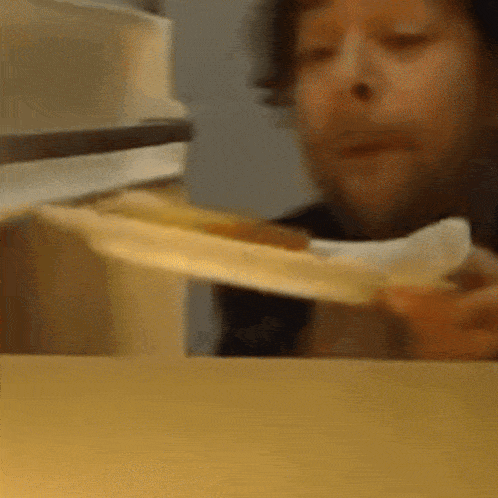 a close up of a person eating a slice of pizza