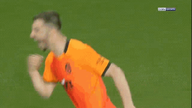 a group of soccer players are running on a field and one has the number 2 on his shirt