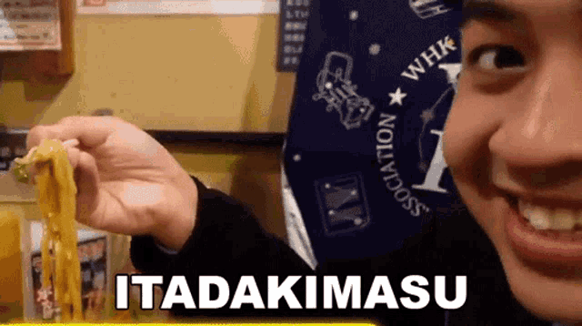 a person holding a piece of food with the word itadakimasu on the bottom