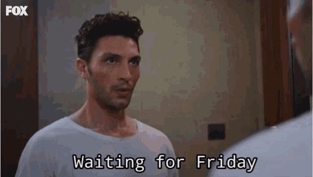 a man is looking at himself in a mirror and says waiting for friday