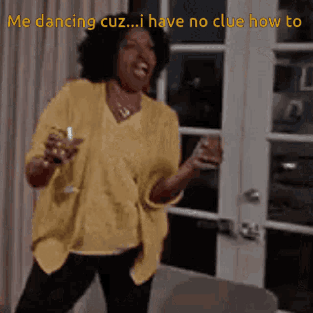 a woman in a yellow shirt is dancing with a glass in her hand