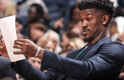 a man in a suit looks at a piece of paper