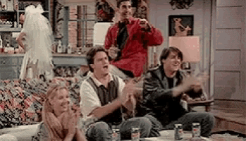 a group of people are sitting on a couch in a living room watching a game .