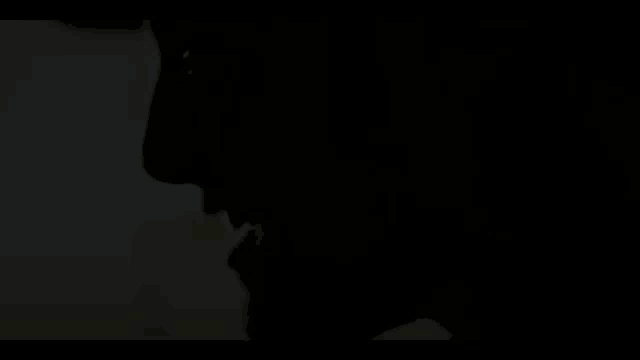 a silhouette of a person 's face in the dark