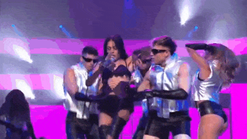 a group of dancers are performing on a stage .