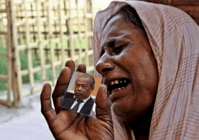 a woman crying while holding a picture of a man in a suit and tie